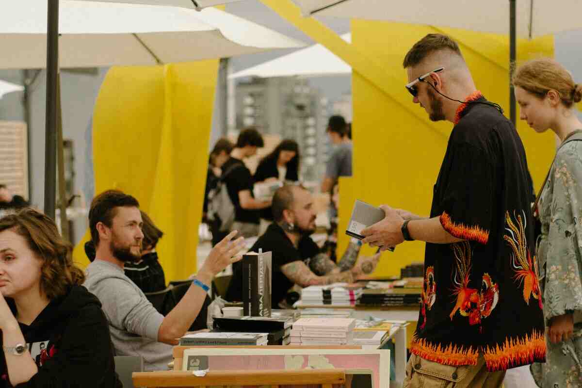 fiera del libro, persone che guardano i libri e parlando con gli autori